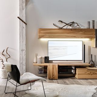 dunkler Sessel vor Wohnzimmerwand aus Holz und Fernseher
