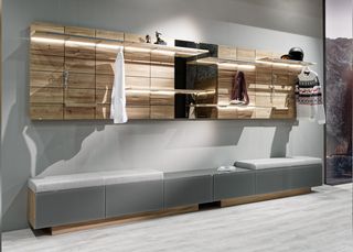 Holzbank mit weißem Leder Garderobenpaneele aus Holz und weise Holzschränke in der Diele