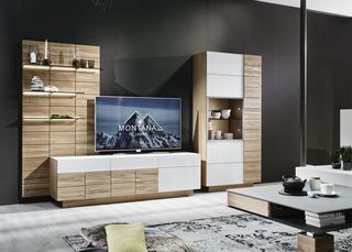 Dunkles Sofa und Teppisch vor Holzwohnwand mit grauem Hängeelement und Fernseher