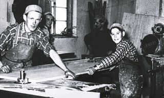 Männer arbeiten im Betrieb mit Holz in schwarz weiß