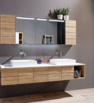 Badezimmer mit Spiegelschrank Waschbecken und Hängeelement aus hellem Holz