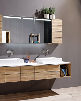 Badezimmer mit Spiegelschrank Waschbecken und Hängeelement aus hellem Holz